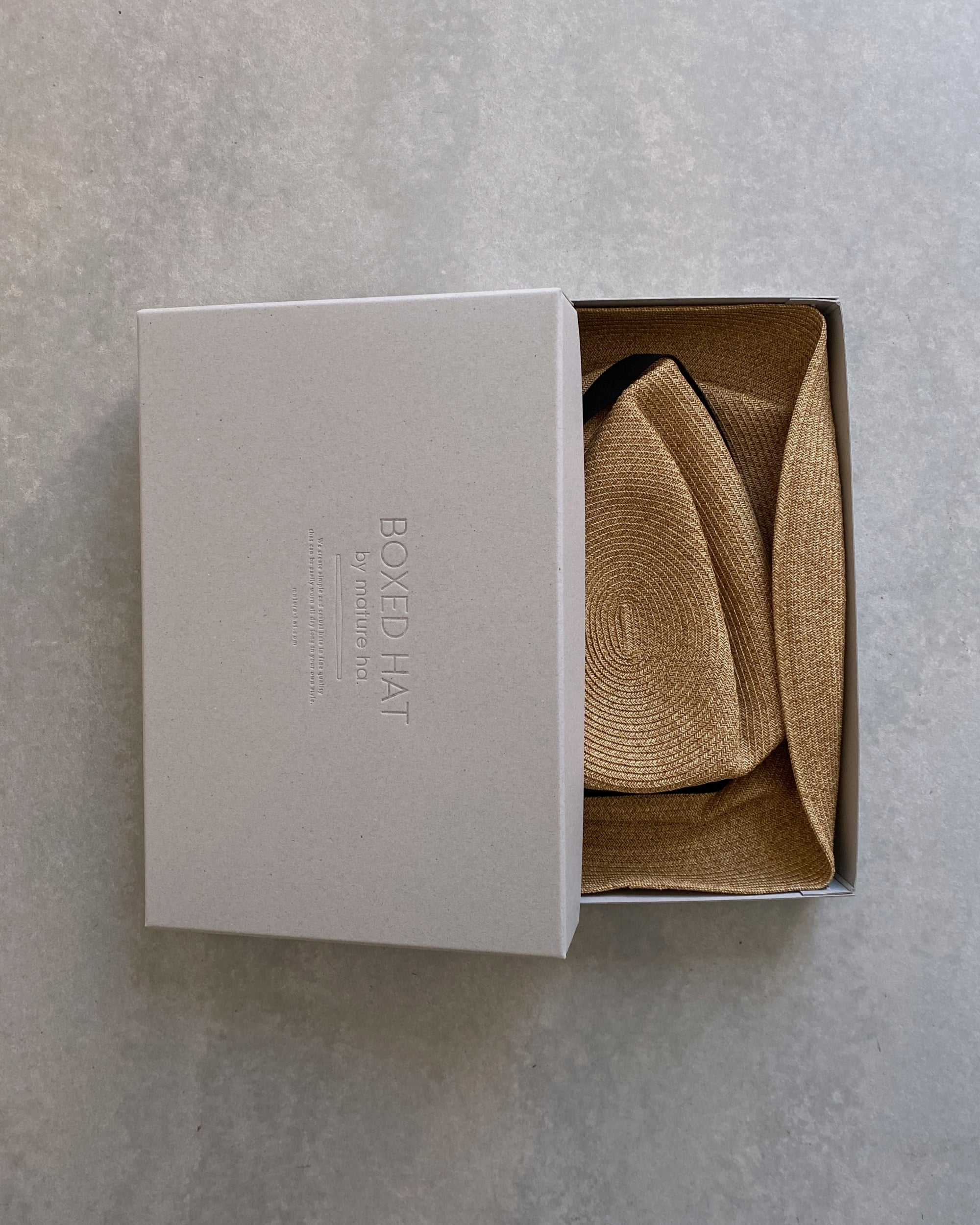 mature ha : boxed hat in sand with carbon ribbon